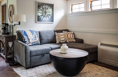 East Jordan Cabin | Cozy River Cabin | Private Deck & Shared Riverside