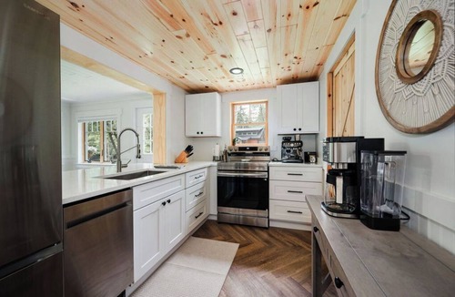 East Jordan Cabin | Cozy River Cabin | Private Deck & Shared Riverside