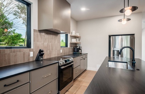 New Plymouth Cabin | Escape to this large Hocking Hills cabin! Sleeps 8 (2BR/Loft/2.5BA). A true luxury Hocking Hills cabin featuring floor-to-ceiling windows, a suspended fireplace, and nearby outdoor sauna pods.