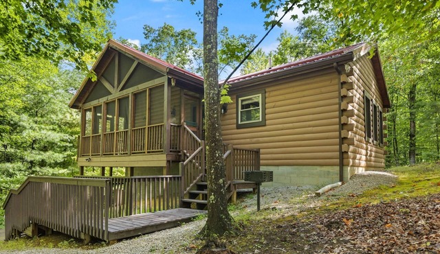 Log Home with fenced in deck & screen porch, cosmopolitan style ranch design.