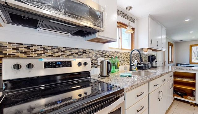Two-story dog-friendly home with a lake view, deck, gas grill