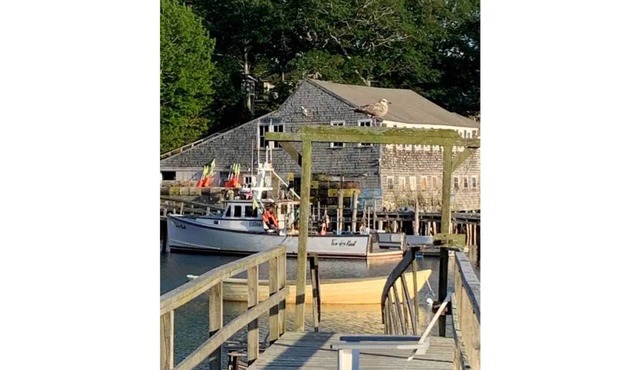 Vintage cabin perched on edge of harbor with dock