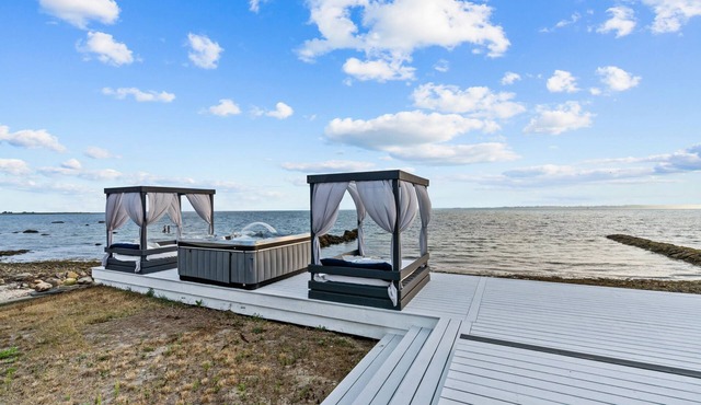 Waterfront Oasis with day beds and hot tub with captivating sunsets.